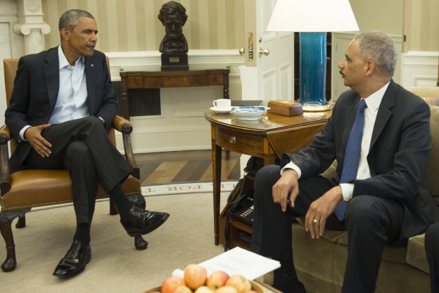 US President Barack Obama(L) and Attorney General Eric Holder speak on the situation in Ferguson, Missouri, where nightly riots have occurred following the shooting on August 9, 2014 of an unarmed African American teenager by police, prior to a meeting in the Oval Office of the White House in Washington, DC, August 18, 2014. AFP PHOTO / Saul LOEB        (Photo credit should read SAUL LOEB/AFP/Getty Images)