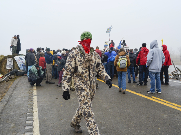 Protesters surround the Rev. Jesse Jackson on Highway 1806 on Thursday. (Prairie Public Broadcasting)