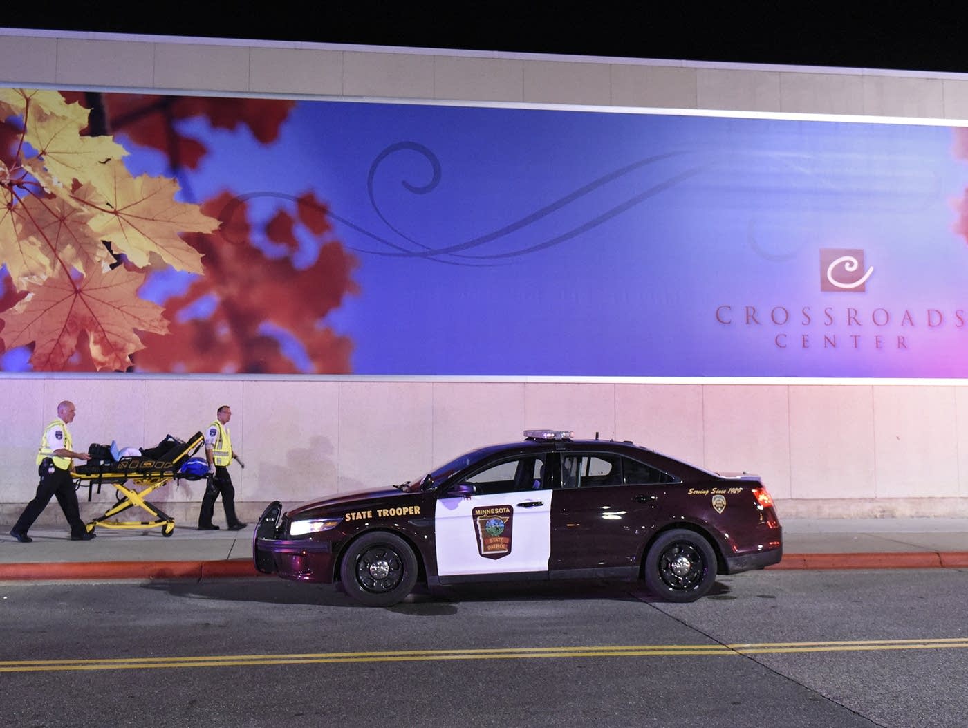 EMT workers move an empty stretcher near the entrance on the north side of Crossroads Center between Macy's and Target Saturday night as officials investigate a reported multiple stabbing incident. (Dave Schwarz | St. Cloud Times)